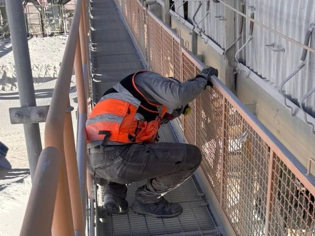 Técnico realizando el levantamiento de una correa transportadora en terreno